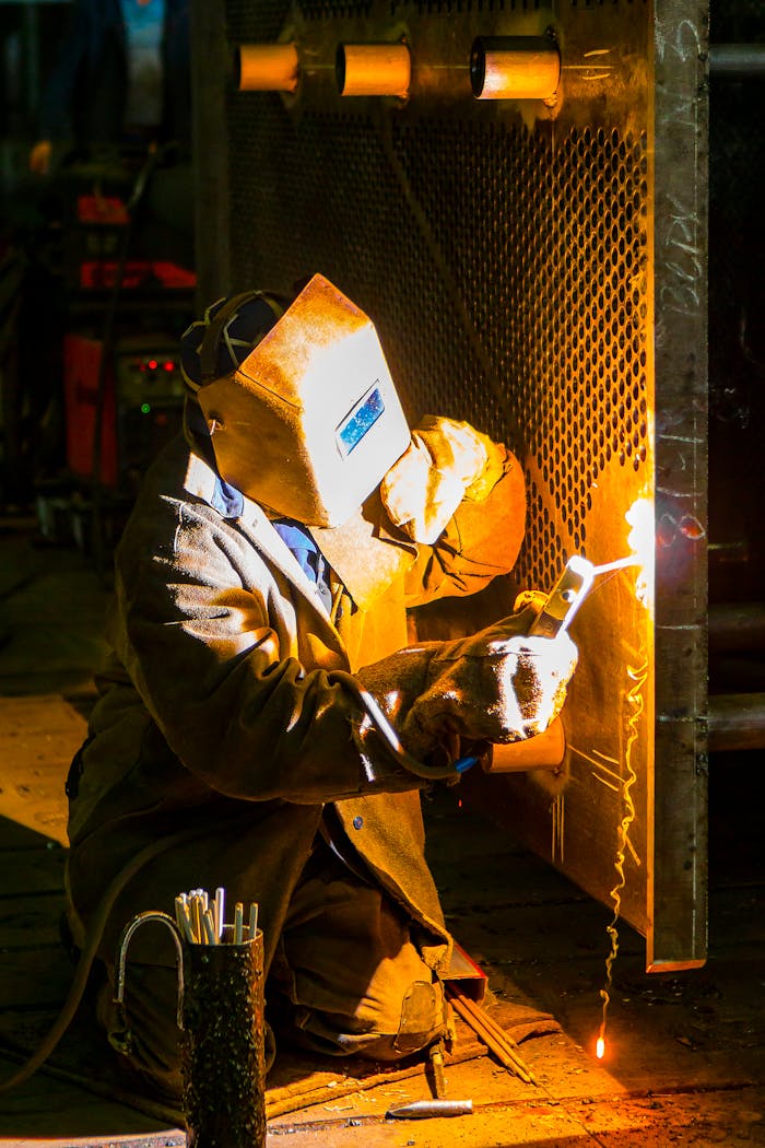 Home A skilled welder works with a torch in an industrial environment, showcasing metalwork expertise.
